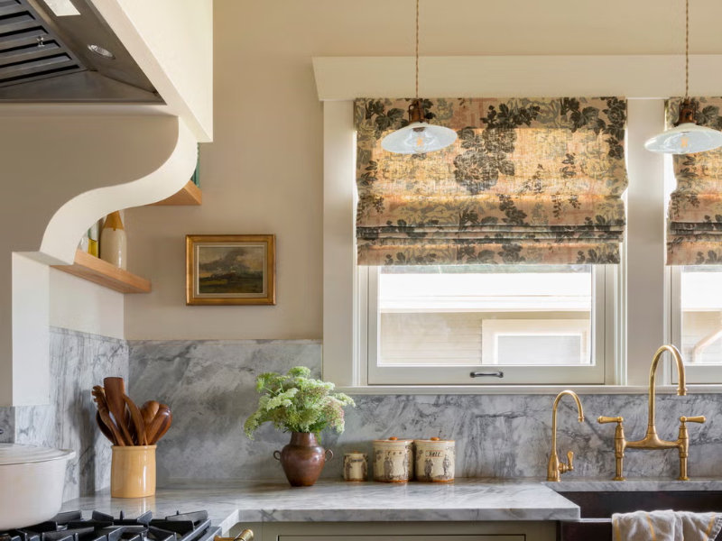 beautiful kitchen with vintage decor, marble counters and backsplash, and gold fixtures