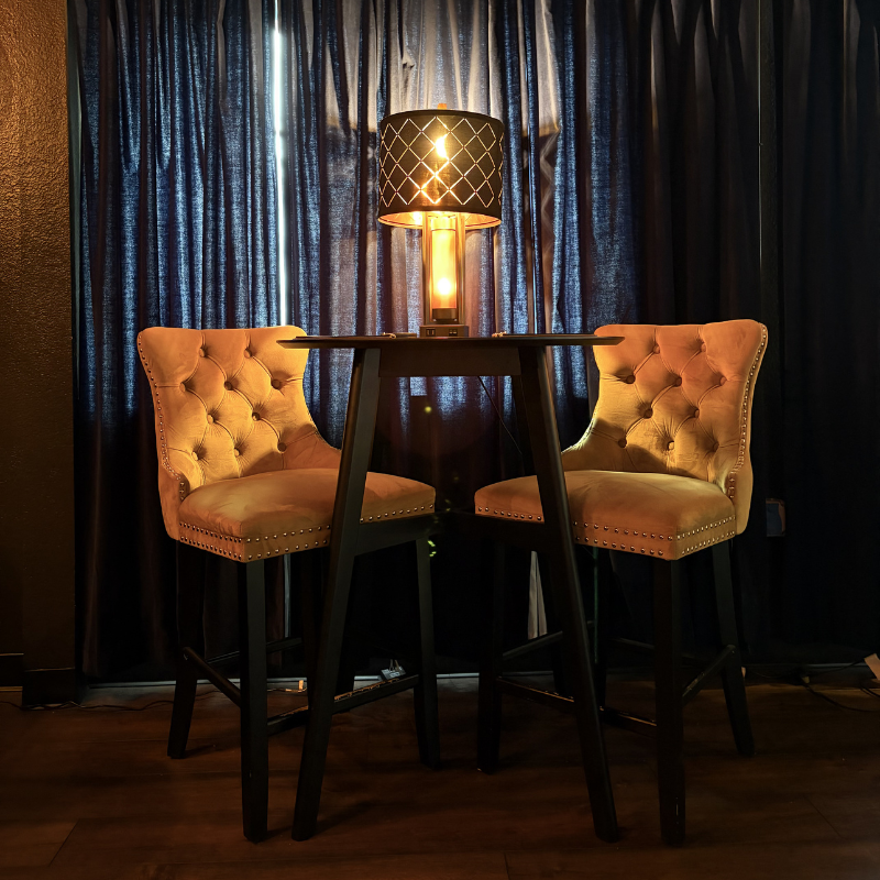 Dark, hardwood flooring in a local lounge with cozy, high-top seating.