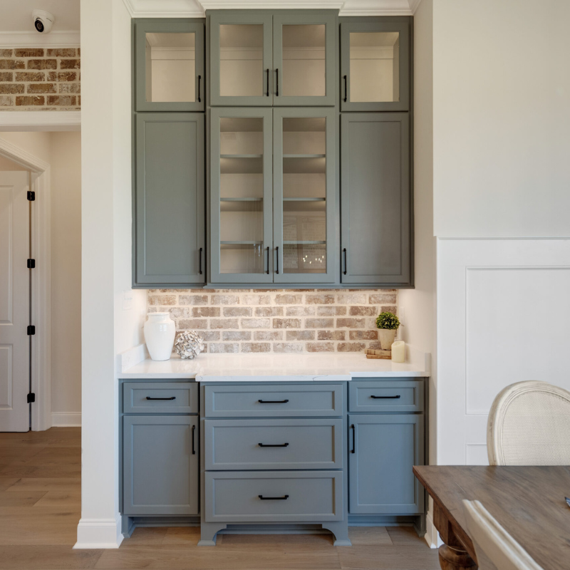 modern kitchen with gray-blue cabinets and exposed brick